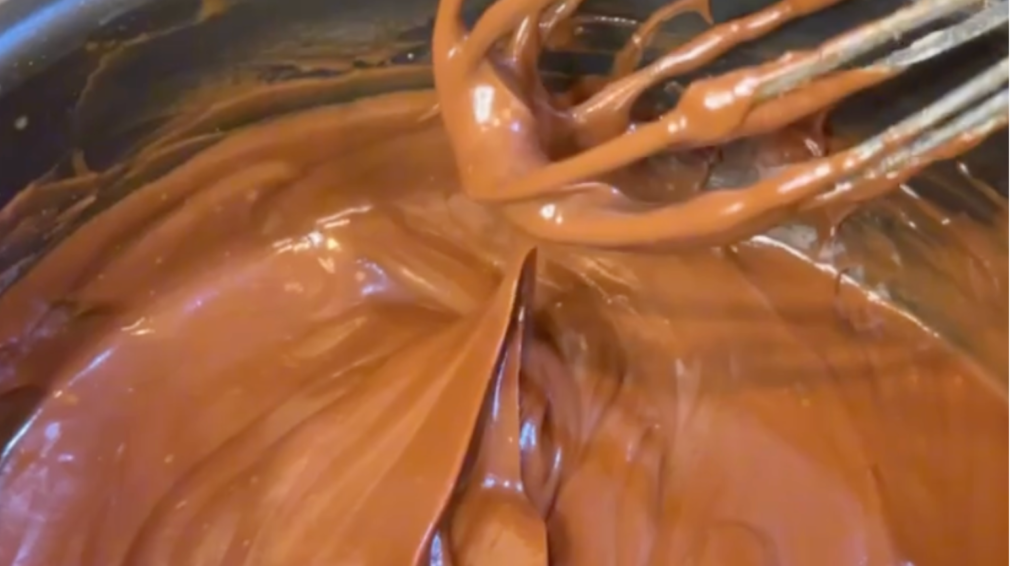 Up close picture of melted chocolate fudge with a whisk